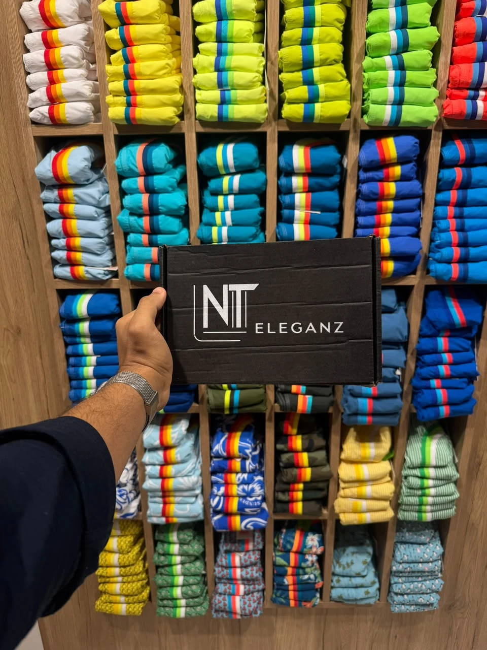 Caixa NT Eleganz entre shorts coloridos